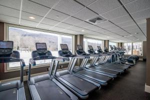 a gym with a row of treadmills and a large window at RiverWalk Resort at Loon Mountain in Lincoln