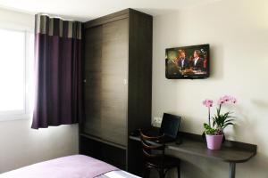 TV a/nebo společenská místnost v ubytování Hôtel des Rosiers