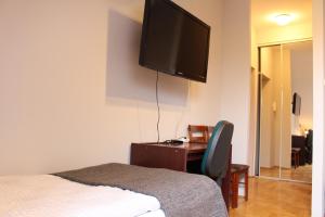 クラクフにあるCracow Old Town Guest Houseのベッドルーム1室(ベッド1台、壁掛けテレビ付)