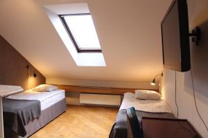Zimmer im Dachgeschoss mit 2 Betten und einem Dachfenster in der Unterkunft Cracow Old Town Guest House in Krakau
