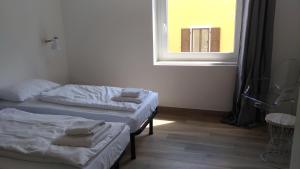 リーヴァ・デル・ガルダにあるAppartamento Brioneの窓付きの小さな部屋のベッド2台
