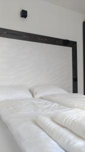 リーヴァ・デル・ガルダにあるAppartamento Brioneの白いベッド(木製のヘッドボード付)