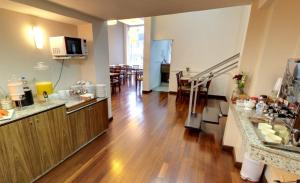 eine Küche und ein Wohnzimmer mit Hartholzboden in der Unterkunft Hotel Urupes in São Bento do Sul