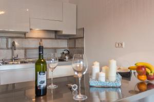 a bottle of wine sitting on a kitchen counter with wine glasses at Monte & Paradiso in Pula