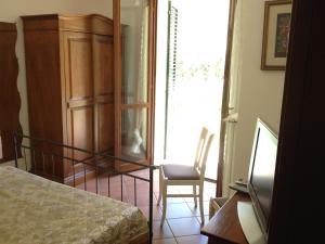 ポッジョ・ムレッラにあるCasa Saturniaのベッドルーム1室(ベッド1台、椅子付)が備わります。