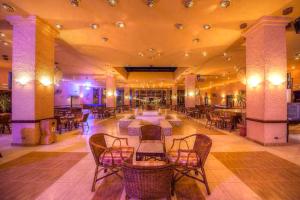 Kefi Palmera Beach Resort El Sokhna - Family Only في العين السخنة: غرفة كبيرة مع طاولات وكراسي في مبنى