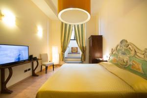 1 dormitorio con 1 cama grande y TV en Locanda Orchidea, en Florencia