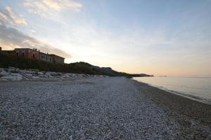 uma praia de seixos com uma casa e o oceano em La Casetta di Adriana em San Vito Chietino