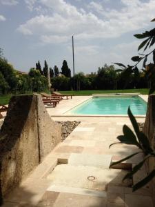 una piscina en un patio con bancos alrededor en Domaine Paul Huc, en Fabrezan