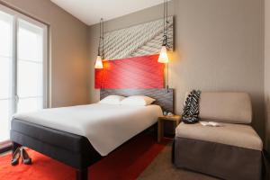 a hotel room with a bed and a chair at ibis Paris Gare De L'Est TGV in Paris +73 photos