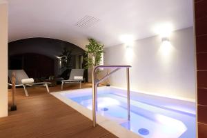 a large swimming pool in a room with a living room at Le Mathurin Hotel & Spa in Paris