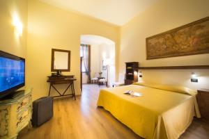 pokój hotelowy z łóżkiem i telewizorem z płaskim ekranem w obiekcie Locanda Orchidea we Florencji