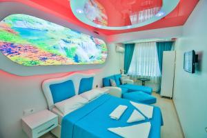 a bedroom with a blue bed and a colorful ceiling at Ay Işığı Pansiyon in Amasra