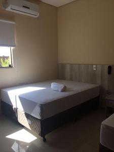a bedroom with a large bed in a room at Hotel Nova Geração in Santa Luzia