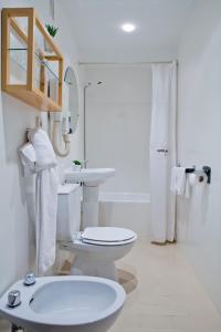 een witte badkamer met een toilet en een wastafel bij Hotel Ibiltze in Lasarte