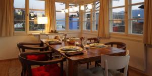 uma sala de jantar com uma mesa com cadeiras e janelas em Chalet INN em Innsbruck