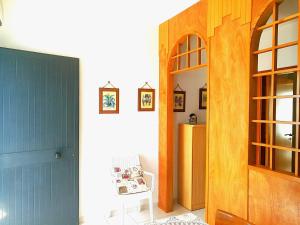 オートラントにあるAppartamento Otrantoの青いドアと椅子のある廊下