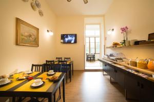 una cocina con mesas y sillas en una habitación en Locanda Orchidea, en Florencia