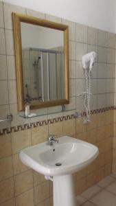 a bathroom with a white sink and a mirror at Hotel Baia Cea in Bari Sardo