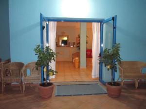 an open door with two potted plants in a room at Hotel Baia Cea in Bari Sardo
