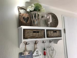 a white shelf with baskets and a mirror at Effe Wad in Buren