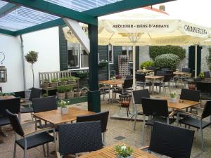 an outdoor patio with tables and chairs and umbrellas at Het Verschil in Zoutelande