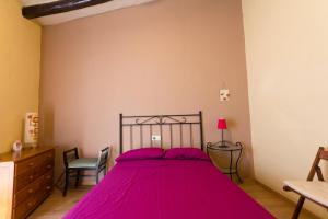 um quarto com uma cama grande e lençóis cor-de-rosa em INNOUTHOME Apartamento Andreu Llambrich em L'Ametlla de Mar