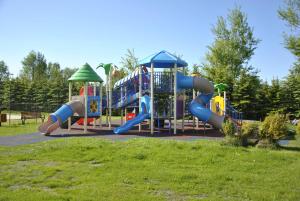a playground with a slide in a park at Nestor Domki in Mrzeżyno