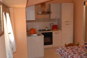 a small kitchen with a sink and a stove at Dietro Piazza Maggiore in Sulmona
