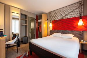 ein Schlafzimmer mit einem großen weißen Bett und einem Stuhl in der Unterkunft ibis Paris Gare De L'Est TGV in Paris + 73 Fotos