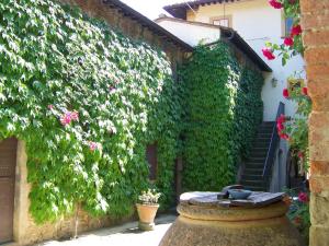 an ivy covered building with a table and flowers at Fattoria di Mandri in Reggello