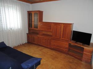 a bedroom with a large wooden cabinet with a flat screen tv at Apartma Lesjak 1 in Bovec