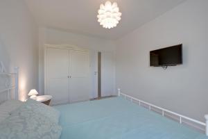 1 dormitorio con 1 cama y TV de pantalla plana en TriApart Deluxe Przy Plaży (Beach Apartment), en Gdansk