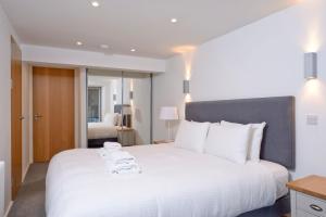 a bedroom with a large white bed with towels on it at Destiny Scotland - Broughton St Lofts in Edinburgh