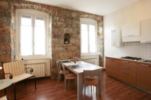 kuchnia ze zlewem i stołem z krzesłami w obiekcie Residence Theresia- Tailor Made Stay w Trieście