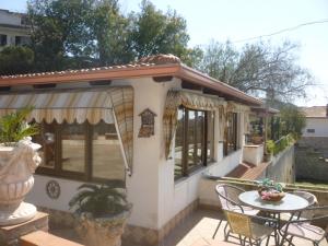 ein Haus mit einer Terrasse mit einem Tisch und Stühlen in der Unterkunft Chalet Rustico in Sessa Aurunca