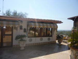 ein Haus mit einer Veranda und einer Terrasse in der Unterkunft Chalet Rustico in Sessa Aurunca
