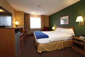 A bed or beds in a room at New Victorian Inn & Suites Kearney
