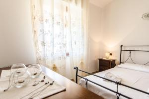 a bedroom with a bed and a table with wine glasses at Azzurromare Casa Vacanze in Teulada