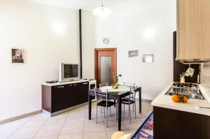 a kitchen with a table and chairs and a tv at Azzurromare Casa Vacanze in Teulada