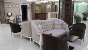 a living room with a white couch and chairs at Aria Hotel Chisinau in Chişinău