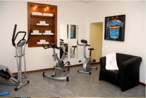a gym with exercise bikes and a chair in a room at Hotel Bel Sit in Comerio