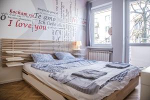 a bedroom with a bed with words on the wall at Apartament Skwer Kosciuszki Gdynia Parking!! in Gdynia