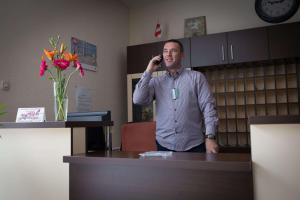 un hombre hablando por un celular en una oficina en Hotel Zelengora, en Foča