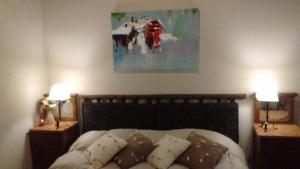 a bedroom with a bed with two lamps and a painting at La Ignacia Bed and Breakfast in Pilar +54 photos