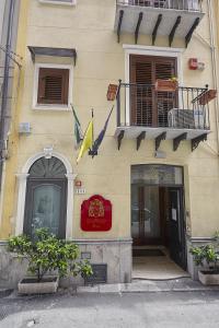 a building with a balcony and a flag on it at Locanda del Gagini in Palermo