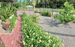 un giardino con fiori gialli e un cartello che dice giardino protetto di Garden Home Seaview a Bang Saphan