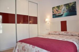 a bedroom with a bed with a purple blanket at ApartSuits Tarragona Rambla Nova 24 in Tarragona