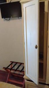 uma porta para um quarto com uma televisão e uma prateleira em La Ignacia Bed and Breakfast em Pilar
