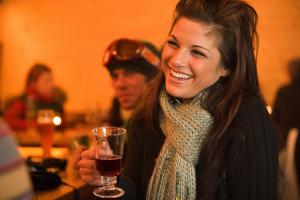 kobieta uśmiechająca się przy kieliszku wina w obiekcie Alm – Chalet Domig w mieście Damüls